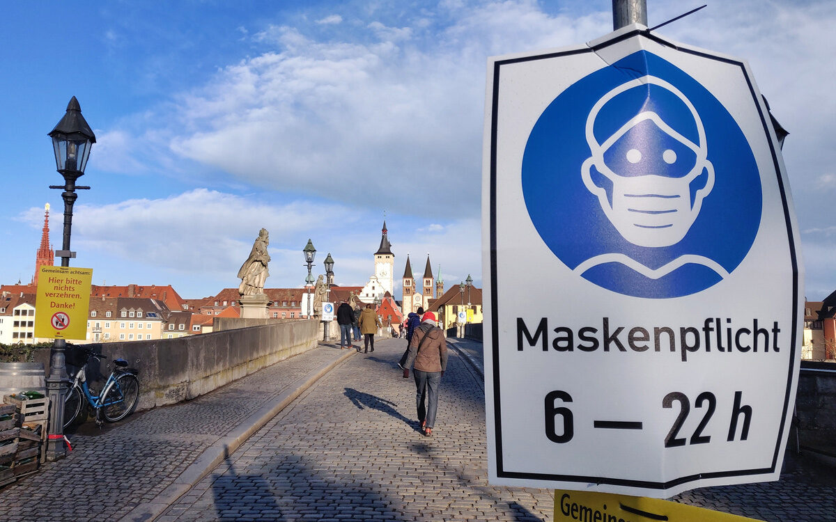 Maskenpflicht angeschrieben auf einem Schild auf der rechten Seite der Alten Mainbrücke in Würzburg in Zeiten von Corona Maskenpflicht angeschrieben auf einem Schild auf der rechten Seite der Alten Mainbrücke in Würzburg in Zeiten von Corona
